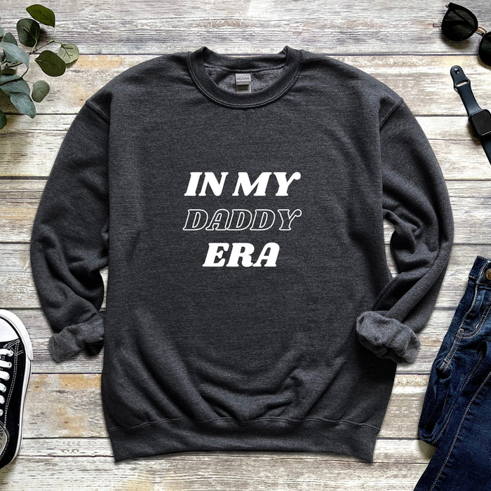 a sweater that says in my daddy era next to a pair of jeans