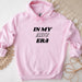 a pink hoodie that says in my abu era